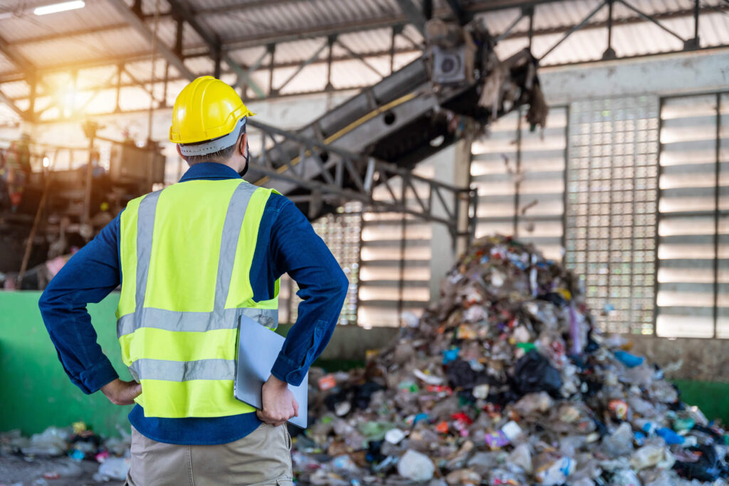 photo-of-a-worker-looking-at-pile-of-scrap